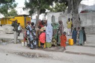 حي حمروين، مقديشو، الصومال. نازحون داخليا من باي وباكول يشترون المياه من أحد التجار. تلبي الخدمات العامة المقدمة بالكاد احتياجات السكان بسبب الدمار الذي حدث. 