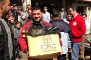 عاملون في اللجنة الدولية والهلال الأحمر العربي السوري يوزعون رزماً من المواد الغذائية. 