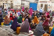 2012年7月，索马里，摩加迪沙，哈迈尔韦恩（Hamar Weyne）地区总部，在与索马里红新月会联合开展的行动中，国内流离失所者从红十字国际委员会那里领取食品。