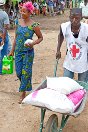 科特迪瓦，马恩，邦戈洛，格朗佩恩，来自科特迪瓦红十字会的志愿者帮助一名妇女搬运粮食。