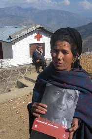Népal, district d'Achham, devant les bureaux de la Croix-Rouge du Népal de Mangalsen. Une femme, dont le mari est disparu, présente le rapport du CICR sur les personnes disparues au Népal.