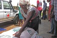 Une femme prend un sac de semences de maïs en vue de la saison de plantation. 