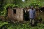 Congo. Province de l'Équateur, Ngona. Un homme debout devant la maison de son frère, une des nombreuses maisons qui ont été détruites durant les affrontements en 2009.