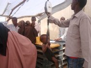 Jilib, Middle Juba, Somália, novembro de 2011. Uma assistente de enfermaria confere o peso de um menino para avaliar se ele precisa ser admitido em um programa de alimentação úmida. 