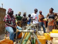 Aeroporto de Bangui. As pessoas da comunidade organizam a distribuição de água. As mulheres formam fila com seus galões de água amarelos.