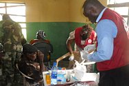 متطوعان من الصليب الأحمر يعالجان في العيادة في واري قروياً مصاباً من بلدة أيوكورمور.