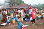 بوتو، نيمبا، ليبيريا. متطوعة في الصليب الأحمر في ليبيريا توزع المياه على اللاجئين من كوت ديفوار والعائلات التي ترعاهم