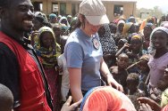 بوتشي، نيجيريا. مندوبة اللجنة الدولية وأحد متطوعي الصليب الأحمر النيجيري يتحدثان إلى مجموعة من النازحين.