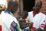 كابيفو، مقاطعة آبلا، تيلابيري، النيجر. متطوعان فيالصليب الأحمر يُقيمان الصحة الغذائية لطفل. 