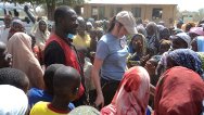 بوتشي، نيجيريا. مندوبة للجنة الدولية ومتطوع من الصليب الأحمر النيجيري يتحدثان مع نازحين نتيجة العنف الدائر بين مجتمعات محلية.