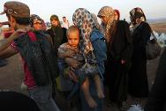 سورية، محافظة إدلب. مدنيون هربوا من القتال في حلب ينتظرون العبور إلى تركيا عند نقطة حدود غير رسمية.