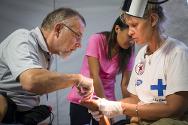 الأطباء والممرضات داخل وحدة الرعاية الصحية الأساسية التي أنشأتها اللجنة الدولية بالتعاون مع الصليب الأحمر الفنلندي يجرون عملية جراحية بسيطة لإزالة شظايا من قدم طفل.