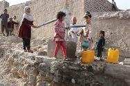 تجمع الأطفال حول المضخات اليدوية المعدنية لملء صفائح المياه.