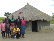 珍妮特和她8个孩子中的6个以及一名红十字国际委员会一线官员在自家新房前合影留念。