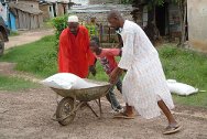 2011年3月25日，科特迪瓦，图莱普勒，得到红十字国际委员会帮助的家庭正在运走他们刚刚领到的应急援助物资，其中包括大米、豆子、食用油和盐。