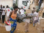 科特迪瓦，迪埃奎，天主教会，一名妇女在科特迪瓦红十字会志愿者的帮助下领走了红十字国际委员会发放的救济物资。
