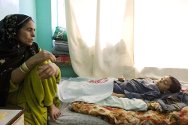 阿富汗，坎大哈，米尔韦斯医院，儿科病房。一位母亲和她8岁的儿子在一起，她的儿子由于感染脑膜炎未得到及时治疗而至今仍在昏迷中。