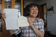 葛运培向记者展示母亲何怡贞当年写的25个字的信。