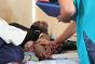 戈马，恩多绍医院，一名红十字国际委员会护士在安抚一位因枪伤造成颅骨骨折的患者。红十字国际委员会外科医生为他实施了移除弹片的手术。