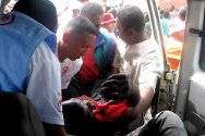 2009年8月，塔那那利佛。在一次反政府示威活动中，马达加斯加红十字会工作人员将一名伤员抬上救护车。