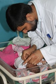 Mirwais Regional Hospital, Kandahar. A doctor examines a baby shortly after birth.