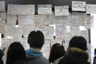 Residents searching for the names of missing relatives in Sendai.