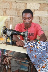 Buutuo town, Nimba County. Liberia. Firmin, an Ivorian tailor from Bin-Houyé, brought his sewing machine with him when he fled to Liberia, so he could earn money to buy food for his family.