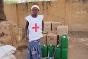 A Mali Red Cross volunteer poses next to food supplies ready for distribution.