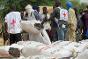 ICRC and Malian Red Cross staff distribute household items.