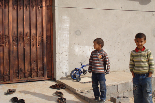 Alrededores de Sirte, Libia. La puerta y la pared de este edificio (vea la imagen ampliada) aun exhiben las marcas de la explosión de un artefacto abandonado sin estallar, en la cual murieron tres miembros de una familia a fines de noviembre.