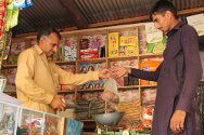 Ghanchattar, Cachemira administrada por Pakistán. Manshad Ahmed atiende a un cliente en el negocio que abrió gracias al apoyo del CICR.