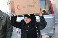 Idlib, Siria. Una mujer se va del punto de distribución con un paquete de alimentos que contiene 25 kg de arroz, guisantes, lentejas y aceite.