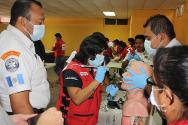 Una socorrista de Cruz Roja Guatemalteca practica la intubación endotraqueal frente a participantes de bomberos voluntarios. 