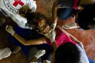 Zona rural de Arauquita, Arauca. Durante un taller dictado por el CICR, una mujer simula estar herida. Sus vecinos demuestran cómo se aplican los primeros auxilios.