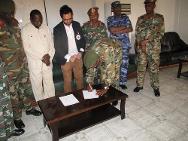 Un delegado del CICR y un funcionario sudanés firman los documentos de entrega para la repatriación de los prisioneros.