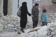 Una familia camina entre los escombros en Alepo, Siria.