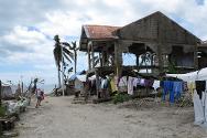 Barangay San Fernando, Basey. Niño jugando en el frente de una casa destruida, en la costa. 