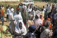 La población se reúne ante la llegada de los camiones del CICR y la Cruz Roja de Chad.