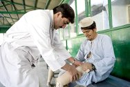 Centre de réadaptation physique du CICR à Kaboul, Afghanistan. Najmuddin soigne un patient qui, comme lui, a été victime d'une mine antipersonnel.
