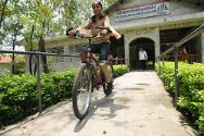 Tulasi sur son vélo devant le centre de réadaptation de l’hôpital Green Pastures.