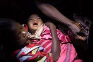 Obo, République centrafricaine. Un distributeur communautaire formé par le CICR examine une fillette qui présente des symptômes de paludisme. Cette maladie fait des ravages dans le pays, en particulier dans les régions dénuées de structures de santé.