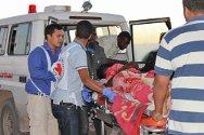 Aéroport de Koufra, Libye. Des membres du CICR conduisent un blessé depuis une ambulance jusqu'à l'avion qui l'attend pour le conduire à Tripoli où il sera soigné.