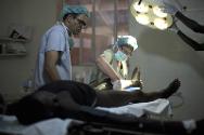 Soudan du Sud. Un chirurgien du CICR désinfecte la jambe d'un patient avant de commencer à opérer. Le patient a été blessé par balles à la jambe durant des affrontements entre tribus et est resté plusieurs jours dans la brousse avant d'être évacué vers l'hôpital de Bor, où le CICR l'a pris en charge.