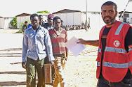 Des migrants font la queue pour contacter leur famille. Avec l’aide des volontaires du Croissant-Rouge libyen, le CICR a permis à la plupart des migrants de contacter leur famille en dehors de la Libye.