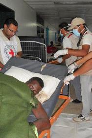 Abdulbadih El Dada, délégué du CICR chargé des premiers secours, et plusieurs membres du personnel du Croissant-Rouge libyen transportent un corps à la morgue tandis qu’une équipe du CICR évacue le personnel et les patients de l’hôpital.