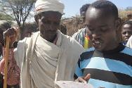 Un père (à gauche) écoute le message que lui a envoyé son fils par l’intermédiaire du CICR, Teletele, dans la zone Borena, région d’Oromia.