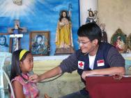 Le Dr Ong Chin Siang examine une fillette à un dispensaire mobile installé dans l'église à moitié en ruines du barangay de Santa Rosa.