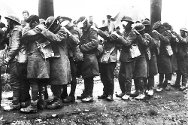 Bataille de l'Estaire : des soldats aveuglés par les gaz attendent devant un poste de premier secours près de Béthune, 10 avril 1918.