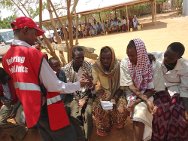 Um dos quatro campos de refugiados de Dadaab, Quênia. Um voluntário da Cruz Vermelha do Quênia ajuda um refugiado a fazer uma ligação para um parente.