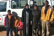 Регейба, Себха, Ливия. Айша, у автомобиля МККК, который доставил ее в Регейбу. Рядом с ней ее сын, внучка и члены принимающей ее семьи.